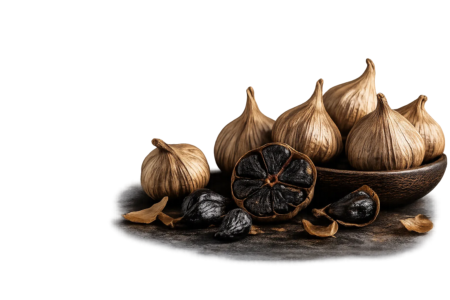 Aged black garlic — whole bulbs and a halved bulb showing the soft black cloves